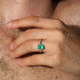 Maria Jose Jewelry Bezel Set Colombian Emerald Ring on model's sandy hand