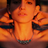 Maria Jose Jewelry Emerald Diamond Necklace on model in water with red light shining